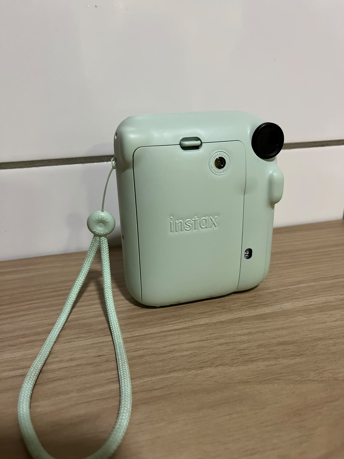 Parte de trás da câmera Instax Mini 12 com alça
